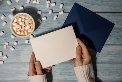 Cropped hands of woman writing in book