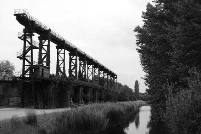 Bridge by trees against sky