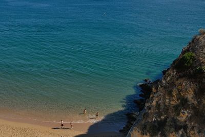 High angle view of people at beach by cliff