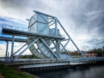 Low angle view of bridge over river against sky