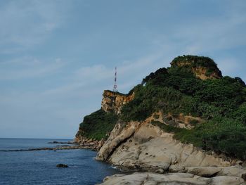 Rock formation on beach against sky