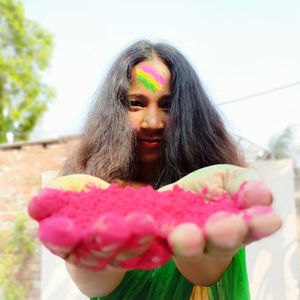 Portrait of woman holding pink flowers