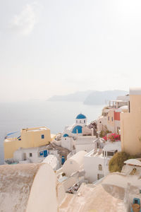 Houses by sea against sky