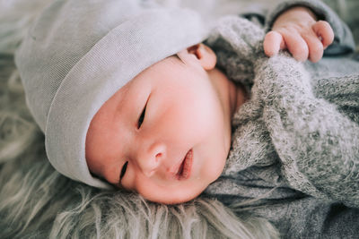 High angle close-up of cute baby boy lying on bed