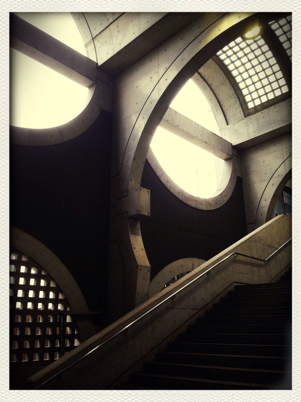 indoors, architecture, built structure, low angle view, arch, steps and staircases, transfer print, staircase, steps, railing, ceiling, auto post production filter, architectural feature, no people, interior, diminishing perspective, modern, spiral staircase, building, escalator