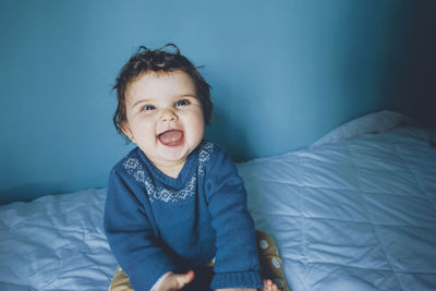 Portrait of smiling girl on bed at home