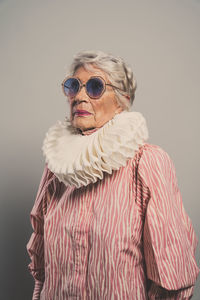 Portrait of young woman wearing sunglasses against black background