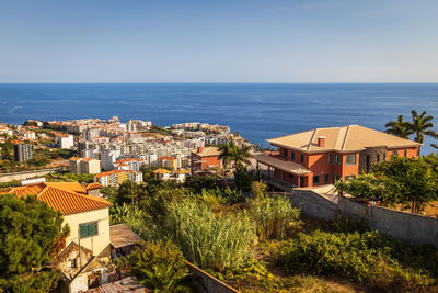 Townscape by sea against blue sky