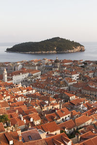 High angle view of townscape by sea against sky with island