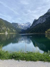 Scenic view of lake by mountains against sky