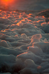 Close up of frozen ice along a beach at sunset in petoskey michigan