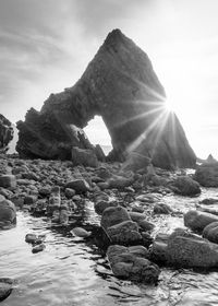 Rocks on beach against sky