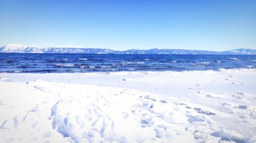 Scenic view of snow covered mountains against clear sky