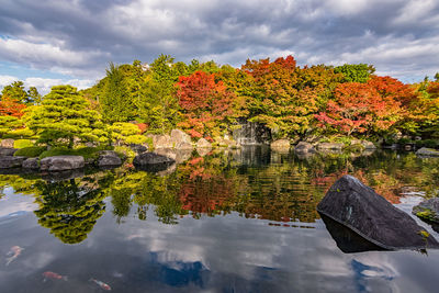 Autumn trees by lake against sky