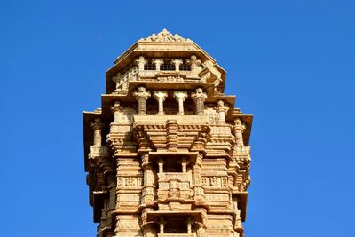 Low angle view of vijaya stambha against clear blue sky