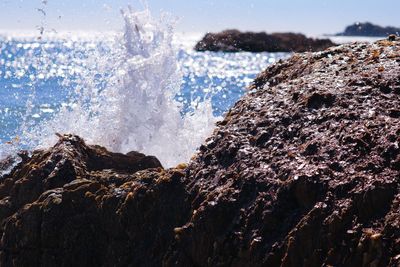 Scenic view of sea waves splashing on rock