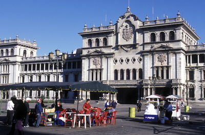 People at outdoors restaurant against cathedral