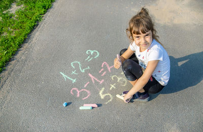 High angle view of girl drawing on road