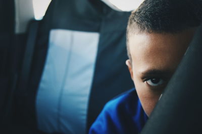 Portrait of boy hiding behind fabric