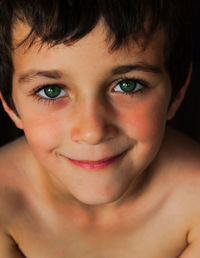 Close-up portrait of smiling shirtless boy