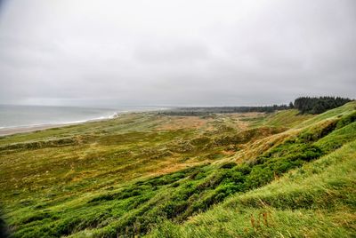 Scenic view of landscape against cloudy sky