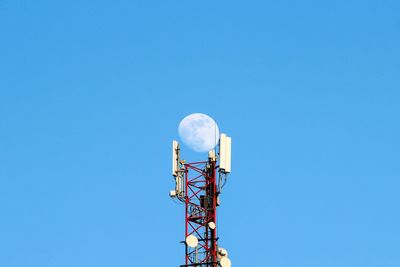 Low angle view of communications tower against clear blue sky