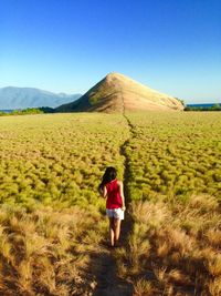 Rear view of woman standing on landscape