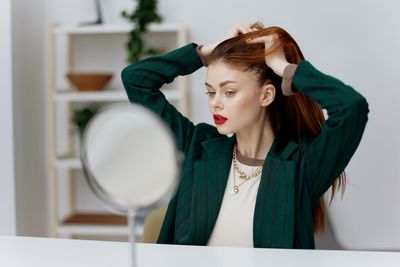 Side view of young woman looking away against white background