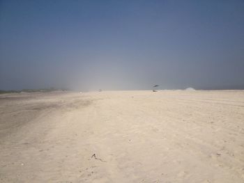 Scenic view of sand dunes against clear sky