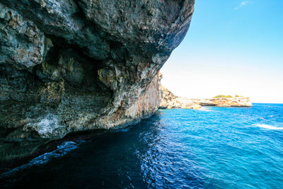 Rock formation in sea against sky