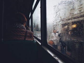 Man looking through window in train