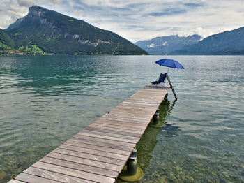 Scenic view of lake by mountain against sky