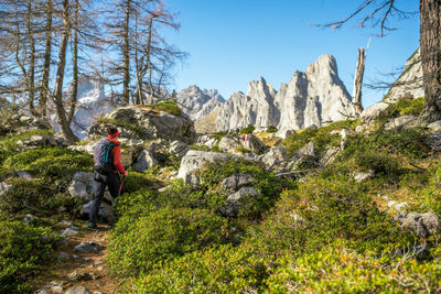 Man on rocks by mountains against sky