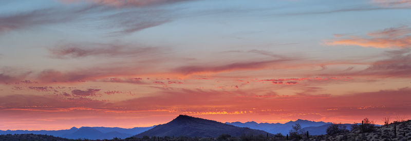 Scenic view of dramatic sky over silhouette landscape