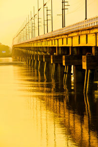 Pier on bridge against sky during sunset