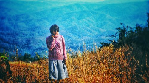 Woman standing on field against sky