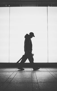 Side view of silhouette man walking against wall