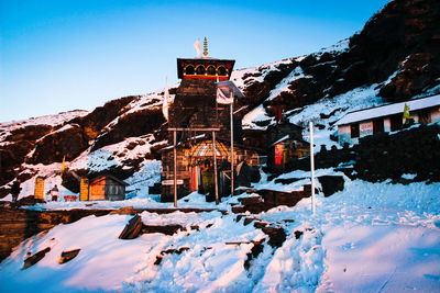 Snow covered buildings against clear sky