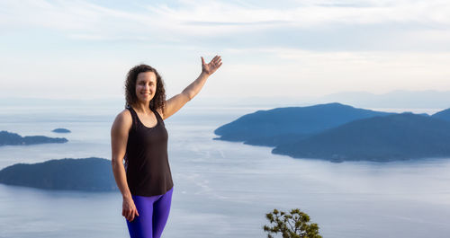 Full length of woman standing on mountain against sky