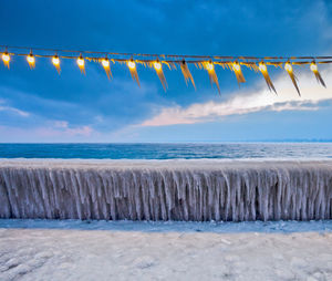 Scenic view of beach against cloudy sky