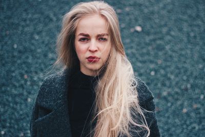 Portrait of young woman against wall