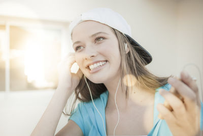 Portrait of smiling young woman listening to music