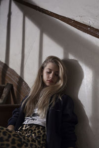 Portrait of young woman against wall