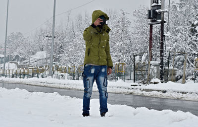 Full length of man standing on snow covered landscape during winter