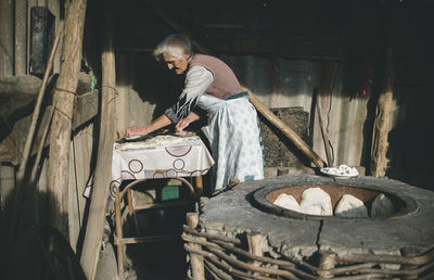 Rear view of woman working on wood