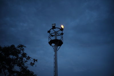 Low angle view of illuminated street light against sky