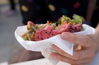 Cropped hand holding burger with missing bites