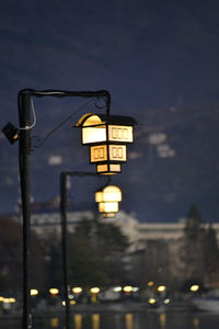 Illuminated street light against sky at night