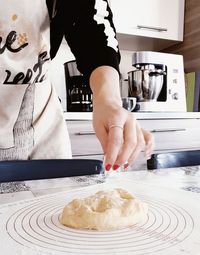 Midsection of woman preparing food in kitchen