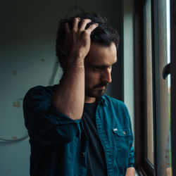 Young man looking through window